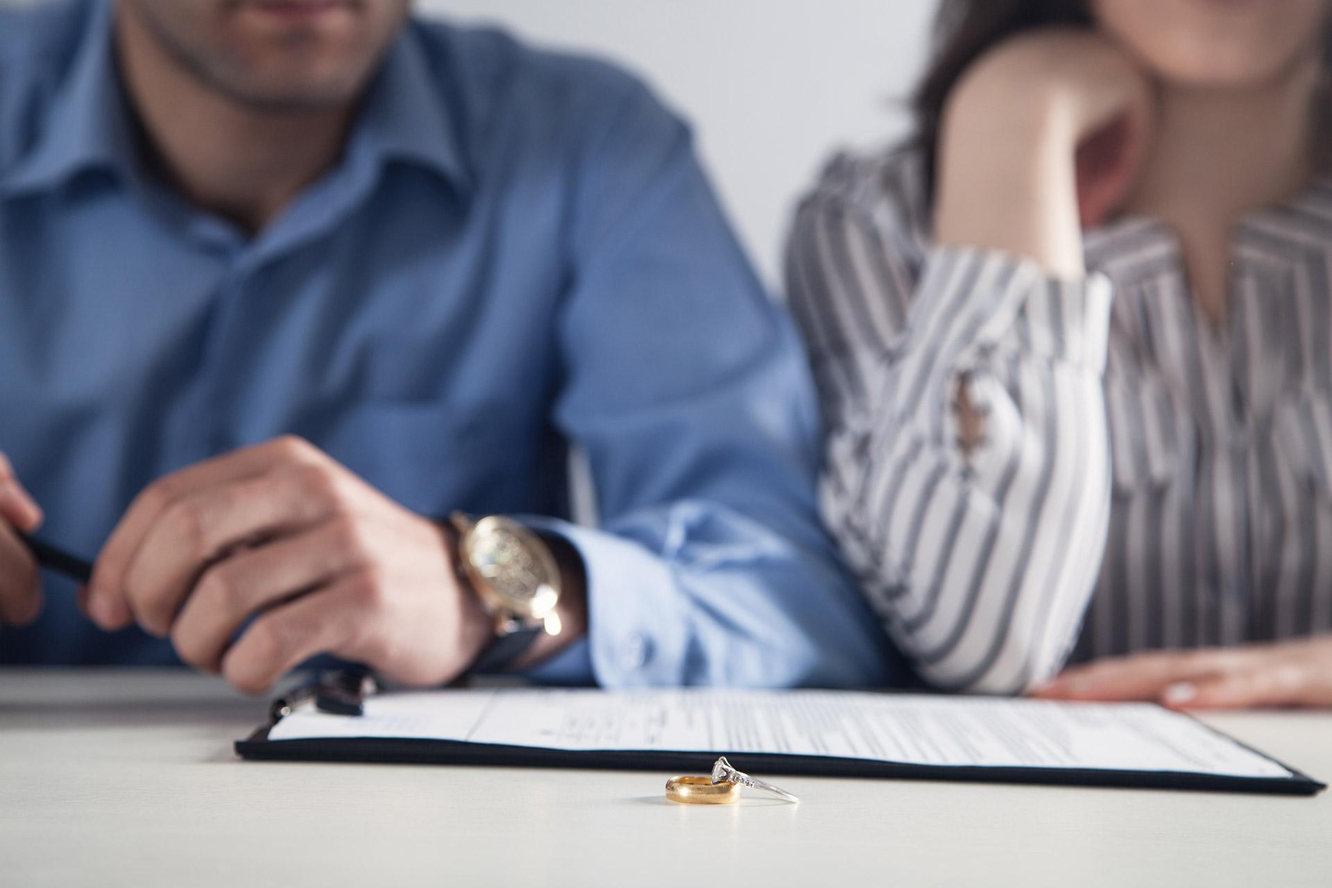 Couple With Divorce Contract and Ring on Desk