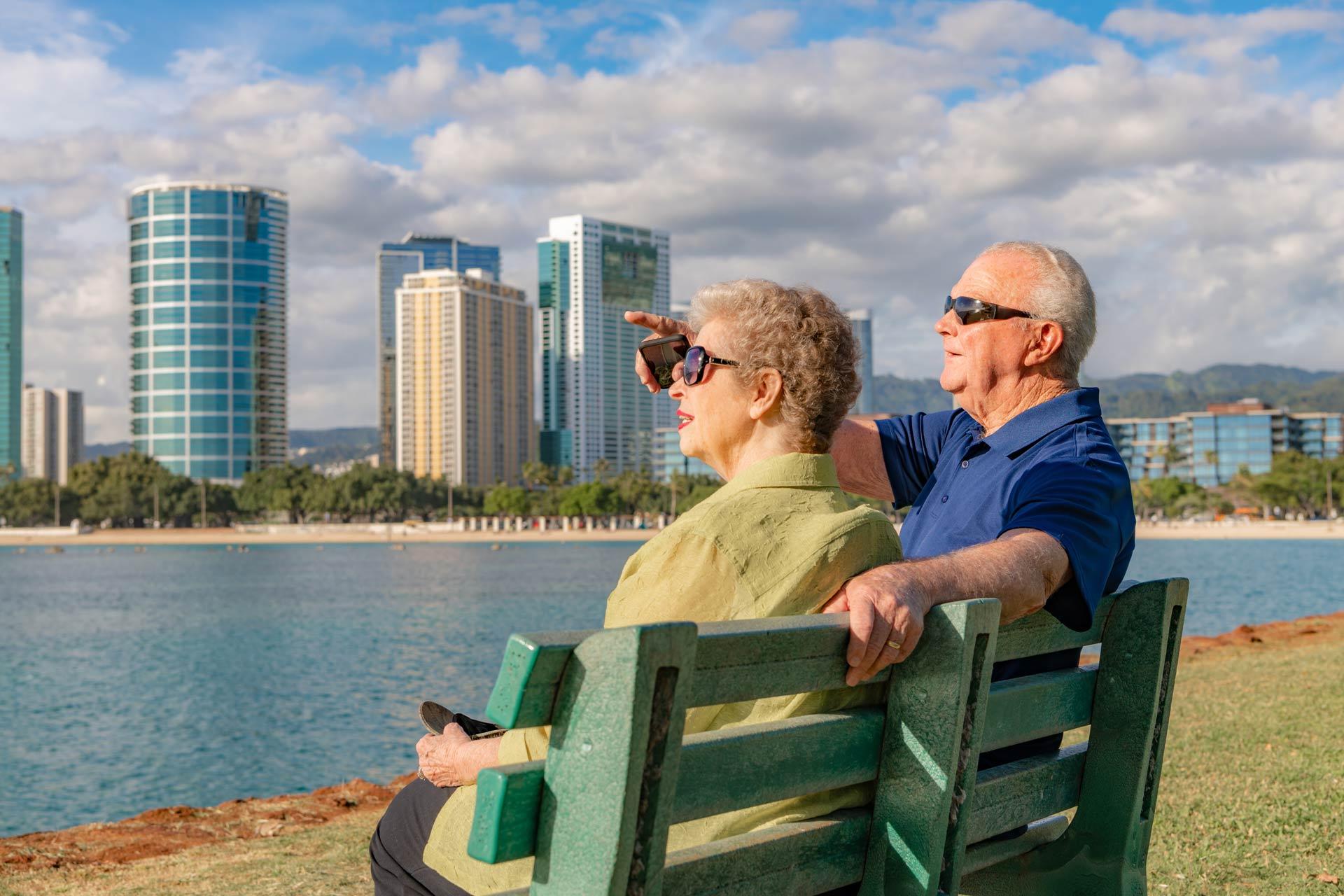 A Beautiful Senior Couple Sits on a Bench and Enjoys the View at Ala Moana Beach in Honolulu, Hawaii